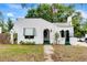 Charming white home with green trim, arched doorway, awning, flagpole, and unique textured facade at 528 S 8Th St, Lake Wales, FL 33853