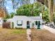 Charming white home with green trim, arched doorway, awning, flagpole, and unique textured facade at 528 S 8Th St, Lake Wales, FL 33853