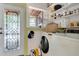 Convenient laundry area with a washing machine, shelving, and a decorative stained-glass door at 528 S 8Th St, Lake Wales, FL 33853