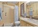 Bathroom featuring a shower with a blue and white shower curtain, white toilet, and light wood vanity at 6719 Canterbury Ne Dr, Winter Haven, FL 33881