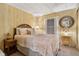 Bedroom with a queen-size bed, side tables, and a lamp near a bright window at 6719 Canterbury Ne Dr, Winter Haven, FL 33881