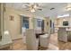 Warm dining area with a wooden table, four chairs, a ceiling fan, and sliding glass doors at 6719 Canterbury Ne Dr, Winter Haven, FL 33881