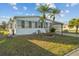 Quaint home with a manicured lawn and attractive landscaping featuring palm trees at 6719 Canterbury Ne Dr, Winter Haven, FL 33881
