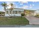 Charming home featuring a front yard with palms, a carport and an enclosed front porch at 6719 Canterbury Ne Dr, Winter Haven, FL 33881