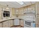 Bright kitchen with light-colored cabinets, white appliances, and a window over the sink at 6719 Canterbury Ne Dr, Winter Haven, FL 33881
