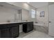 Modern bathroom with double vanity, sleek black cabinets, a tub, and tile floors at 718 Whistling Straits Blvd, Davenport, FL 33896