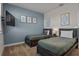 Stylish bedroom with two twin beds, a blue accent wall, and framed botanical prints at 718 Whistling Straits Blvd, Davenport, FL 33896