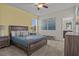Cozy bedroom with neutral colors, a ceiling fan, a large bed, and ensuite bathroom access at 718 Whistling Straits Blvd, Davenport, FL 33896