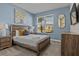 Cozy bedroom with wooden furniture, a patterned bedspread, and a relaxing ambiance at 718 Whistling Straits Blvd, Davenport, FL 33896