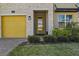 The home has a striking yellow door, stone facade, and manicured landscaping at 718 Whistling Straits Blvd, Davenport, FL 33896