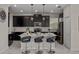 Modern kitchen featuring dark cabinets, a white countertop island with seating, stainless steel appliances, and elegant pendant lighting at 718 Whistling Straits Blvd, Davenport, FL 33896