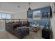 Comfortable living area features a gray sofa, accent wall, modern decor, and natural light at 718 Whistling Straits Blvd, Davenport, FL 33896