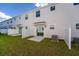 A view of the backyard with grass, white fence, and a sliding glass door leading into the townhouse at 7521 Stone Creek Trl, Kissimmee, FL 34747