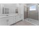 Primary bathroom featuring double sinks, a glass shower, and tile flooring at 7521 Stone Creek Trl, Kissimmee, FL 34747