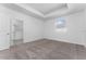 Spacious bedroom features tray ceiling, neutral carpet and access to the ensuite bathroom at 7521 Stone Creek Trl, Kissimmee, FL 34747