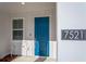 Close-up of front door area featuring the house number and blue door at 7521 Stone Creek Trl, Kissimmee, FL 34747