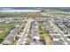 Aerial view of a residential community with houses, streets, and a distant lake at 7641 Modica St, Clermont, FL 34714