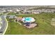 Aerial view of a community featuring a pool, clubhouse, playground, and green spaces at 7641 Modica St, Clermont, FL 34714
