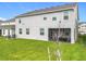 A view of the backyard with a well-maintained lawn and spacious screened-in lanai at 7641 Modica St, Clermont, FL 34714