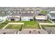 An aerial view of a backyard featuring a spacious lawn, screened-in lanai and partial fence for privacy at 7641 Modica St, Clermont, FL 34714