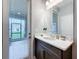 Bathroom with white countertop, dark vanity, mirror, and glass door to the outside at 7641 Modica St, Clermont, FL 34714