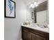 Half bathroom with a dark wood vanity, white countertop, and decorative accents at 7641 Modica St, Clermont, FL 34714