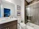 Bathroom with a white countertop, dark vanity, mirror, and glass enclosed shower at 7641 Modica St, Clermont, FL 34714