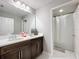 Bright bathroom with double vanity, dark cabinets, and shower/tub combo at 7641 Modica St, Clermont, FL 34714