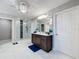 Well-lit bathroom with a glass shower, modern vanity, and marble tile at 7641 Modica St, Clermont, FL 34714