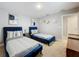 Bright bedroom featuring two twin-sized beds with blue velvet frames and neutral decor at 7641 Modica St, Clermont, FL 34714