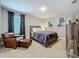 Comfortable bedroom featuring chair with ottoman, soft carpet, and serene neutral color palette at 7641 Modica St, Clermont, FL 34714