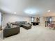 Large bonus room with a leather sectional sofa, pool table, and neutral carpet at 7641 Modica St, Clermont, FL 34714
