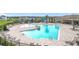 Community pool area with a splash pad, covered seating, lounge chairs, and umbrellas at 7641 Modica St, Clermont, FL 34714