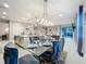 Dining room with a glass table, plush chairs and view into an open concept kitchen and living room at 7641 Modica St, Clermont, FL 34714