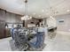 Open dining area with a glass table, gray chairs, and views into the kitchen at 7641 Modica St, Clermont, FL 34714