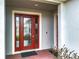 A welcoming red front door with sidelights and brick pavers at 7641 Modica St, Clermont, FL 34714