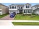 Charming two-story home with a manicured lawn, tasteful landscaping, and a brick driveway at 7641 Modica St, Clermont, FL 34714