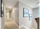 Hallway featuring neutral walls, carpet, and artwork, leading to other rooms at 7641 Modica St, Clermont, FL 34714
