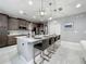 Kitchen island with white countertop, stylish pendant lights and seating for four at 7641 Modica St, Clermont, FL 34714