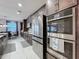 Modern kitchen featuring stainless steel appliances and ample cabinet space, adjacent to a dining area at 7641 Modica St, Clermont, FL 34714