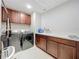 Well-equipped laundry room with modern washer, dryer, and ample cabinet space at 7641 Modica St, Clermont, FL 34714