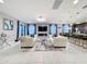 Bright, open-concept living room featuring dual sofas, fireplace, and seamless flow into the kitchen and dining area at 7641 Modica St, Clermont, FL 34714