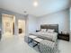 Spacious bedroom with a bathroom suite and stylish ottomans at 7641 Modica St, Clermont, FL 34714