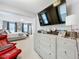 Main bedroom with a TV and ensuite sitting area, featuring neutral decor at 7641 Modica St, Clermont, FL 34714