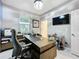 Bright office featuring a large desk and chair, with a door to another room at 7641 Modica St, Clermont, FL 34714