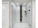 Modern shower featuring elegant glass enclosure, with rainfall shower head, handheld wand, and marble-like tile at 7641 Modica St, Clermont, FL 34714