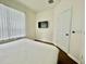 Bright bedroom with a sleek TV, minimalist decor, and a window bringing in natural light at 7670 Otterspool St, Kissimmee, FL 34747