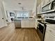 Contemporary kitchen featuring stainless appliances, white cabinetry, and open design to living area at 7670 Otterspool St, Kissimmee, FL 34747