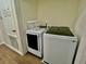 Bright laundry room with white washer, dryer, and basket for added convenience at 7670 Otterspool St, Kissimmee, FL 34747