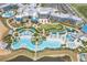 A stunning aerial view of a resort with multiple pools, green spaces, and a lakeside setting at 8012 Lost Shaker Ln, Kissimmee, FL 34747
